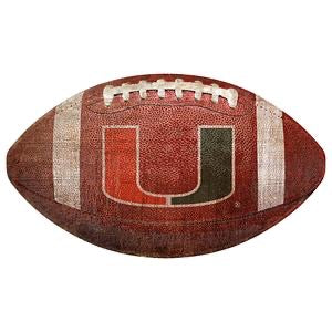 A worn american football with the letter "u" inside a stylized shield, prominently displayed on its side.
