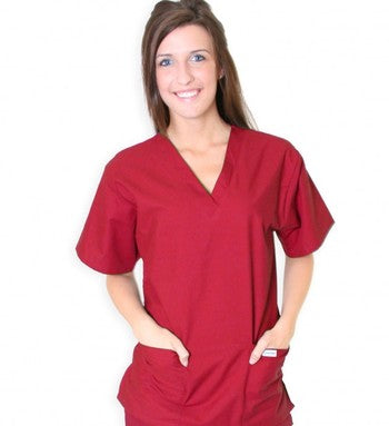 A woman in a maroon scrub top smiles while standing against a white background.