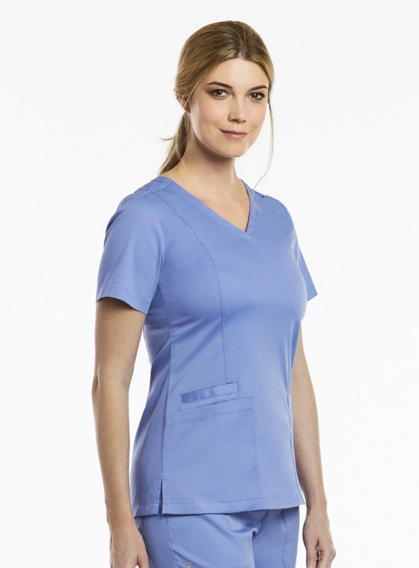 Woman in a 3501 Both Side V-Neck Top standing against a white background, looking at the camera with a neutral expression.