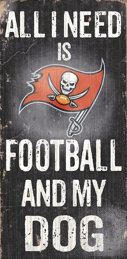 Sign with the text "all i need is football and my dog" featuring a tampa bay buccaneers logo, displayed on a worn, wooden background.