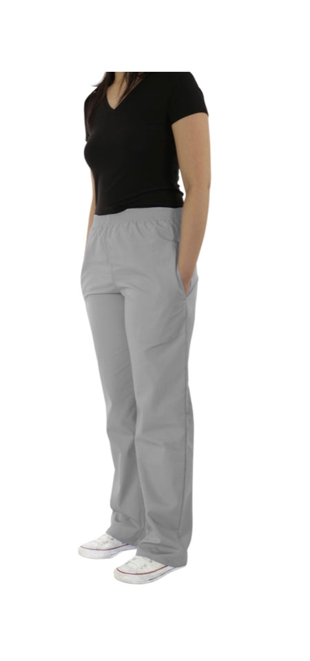 A woman standing in profile wearing a black t-shirt, UltraSoft Unisex Classic Elastic Waist Scrub Pants 300C, and white sneakers, isolated on a white background.