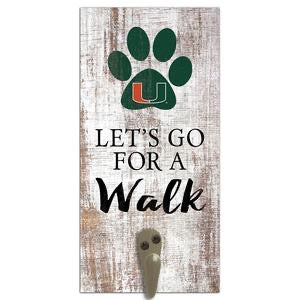Decorative wall-mounted key holder featuring the phrase "let's go for a walk" and a university of miami logo on a rustic wood background.