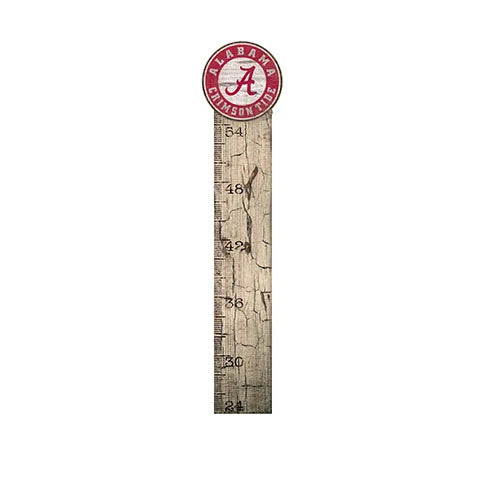 A wooden growth chart with a distressed finish, featuring a white scale in inches and topped with a circular university of alabama logo.