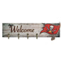 Wooden "welcome" sign with a pirate flag design and four hooks, mounted on a distressed wood background.