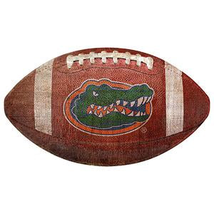 A University of Florida 12" Football Shaped Sign with the Florida Gators logo, featuring a detailed alligator graphic on a textured brown surface.