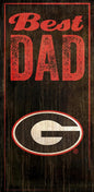A vintage-style decorative sign reading "best dad" with a weathered georgia bulldogs logo in an oval, all against a dark, distressed wooden background.