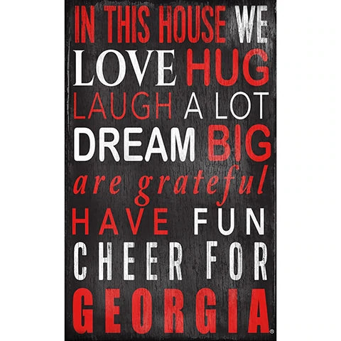 Decorative sign with phrases "in this house we love, hug, laugh a lot, dream big, are grateful, have fun, cheer for georgia" in white/red letters on a black background.