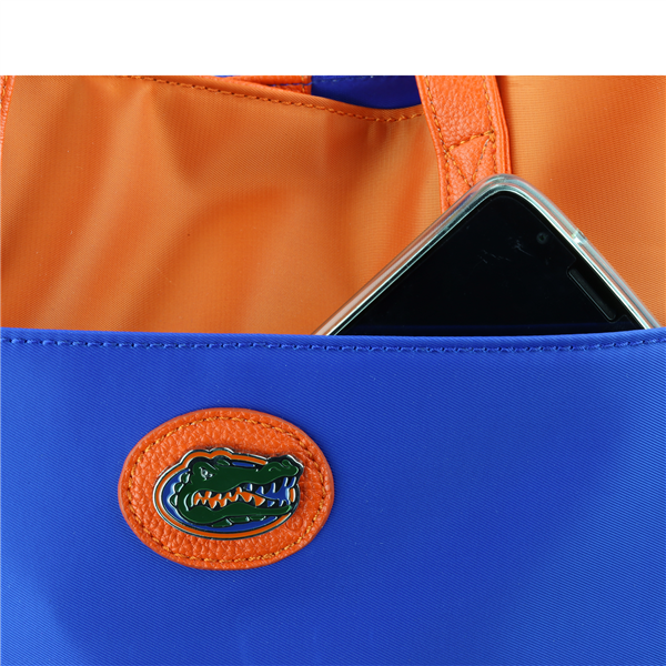 Smartphone partially inserted in a blue and orange The Phyllis Handbag (University of Florida Gators).