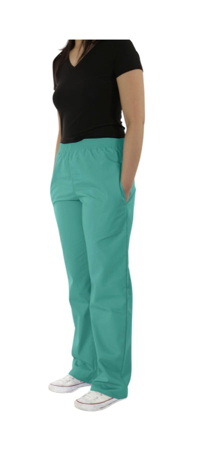 A woman standing in a black t-shirt and UltraSoft Unisex Classic Elastic Waist Scrub Pants 300C with white sneakers, with one hand in her pocket, facing slightly to the side.