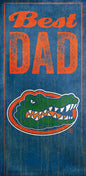 A University of Florida Best Dad Sign featuring the words "best dad" in orange text above the logo of a green alligator in an oval, all set against a blue distressed background.