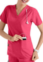 A smiling female healthcare professional in a CROSS FLEX V-NECK MEDIA SCRUB TOP C12110 placing a smartphone into her pocket, with a stethoscope around her neck.