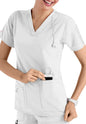A smiling healthcare worker in a white uniform inserts a CROSS FLEX V-NECK MEDIA SCRUB TOP C12110 into her pocket.