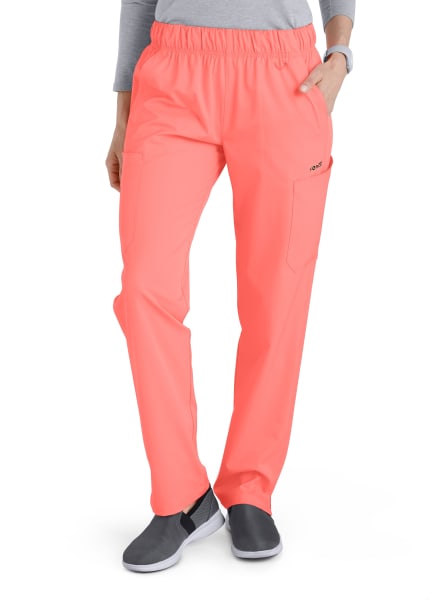 Bright neon orange Comfort Waist Utility Cargo Pants (Women's C53106) with an elastic waistband, side pocket featuring a logo, and paired with black and gray sneakers.