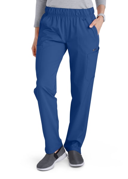 A woman wearing Comfort Waist Utility Cargo Pants (Women's C53106) and gray slip-on shoes, standing with one hand partially in a pocket.