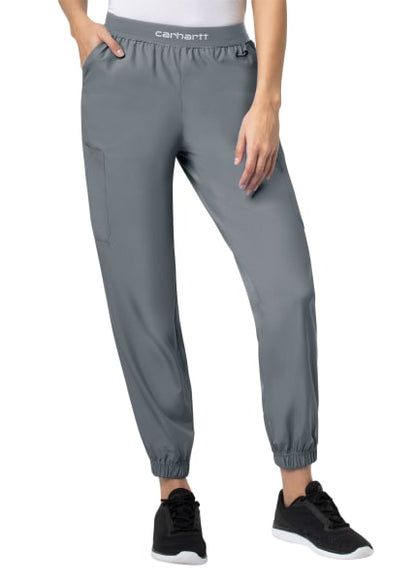 Woman wearing Carhartt Liberty Comfort Cargo Jogger Scrub Pants (Women's C54106) and black sneakers, standing with her hand slightly touching her thigh.