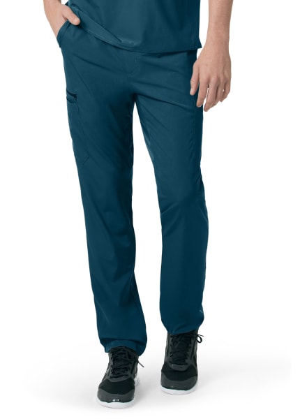 Person wearing blue CARHARTT C55106 - MEN'S ATHLETIC CARGO PANT and black sneakers, focusing on the lower half of the body.