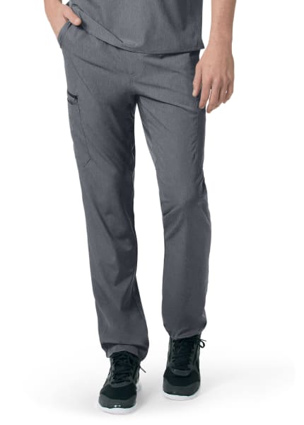 A person wearing Carhartt C55106 - Men's Athletic Cargo Pant and dark green sneakers, standing with one hand partially in a pocket.