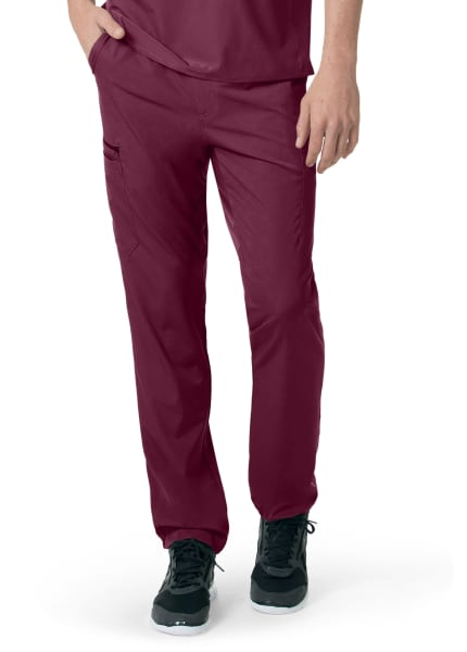A person wearing dark red Carhartt C55106 - Men's Athletic Cargo Pant and black sneakers, with hands partially tucked into pockets.