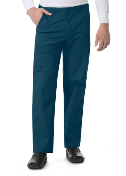 Man in white shirt and teal scrubs standing with hand in pocket, focusing on the Carhartt Ripstop Rugged Flex Straight Leg Cargo Pants (Men's C56418) and black shoes.