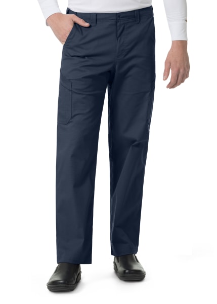 Man wearing Carhartt Ripstop Rugged Flex Straight Leg Cargo Pants (Men's C56418) with side pockets, paired with a white shirt and black shoes, standing with one hand in pocket.