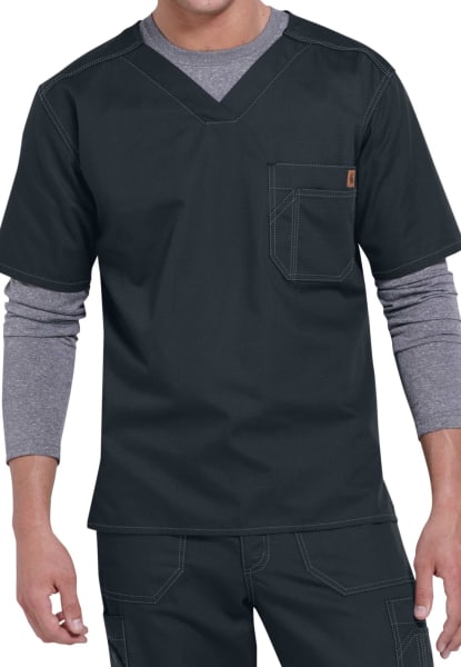 A man wearing a SOLID RIPSTOP SCRUB UTILITY TOP (Men's C15108) with a v-neck and layered gray long-sleeve shirt underneath, featuring visible stitching details and a pocket on the chest.