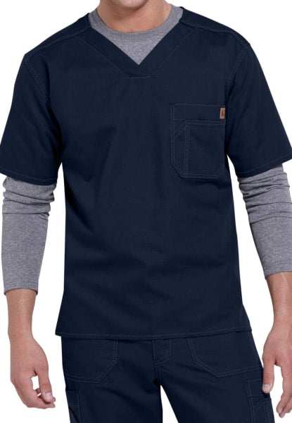 Man in SOLID RIPSTOP SCRUB UTILITY TOP (Men's C15108) medical scrubs with layered gray undershirt, standing with hands partly visible.