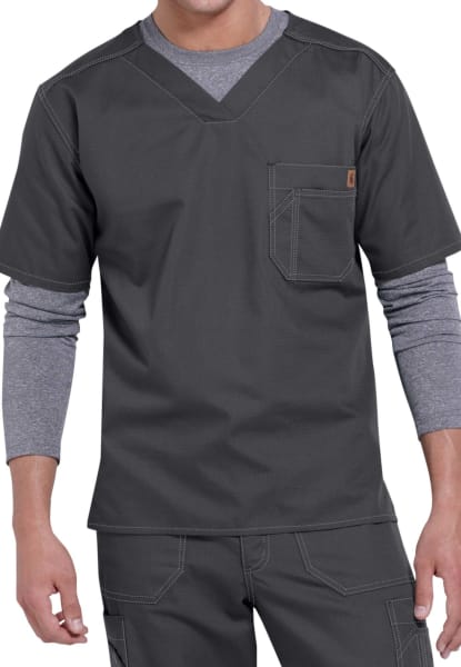 Man wearing a modern charcoal gray SOLID RIPSTOP SCRUB UTILITY TOP (Men's C15108) uniform with a layered long-sleeve shirt underneath, featuring a v-neckline and a chest pocket.