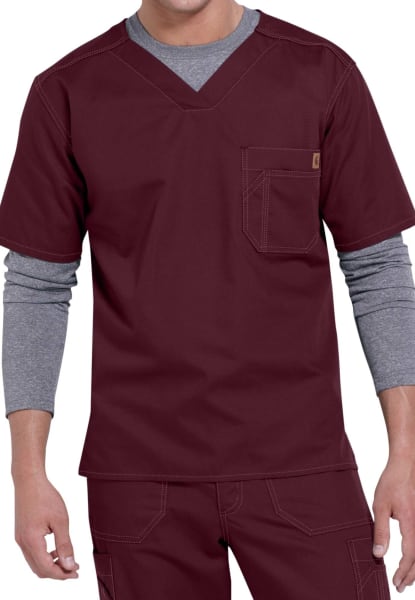 A man wearing a SOLID RIPSTOP SCRUB UTILITY TOP (Men's C15108) with a chest pocket and grey layered undershirt, paired with coordinating scrub pants.